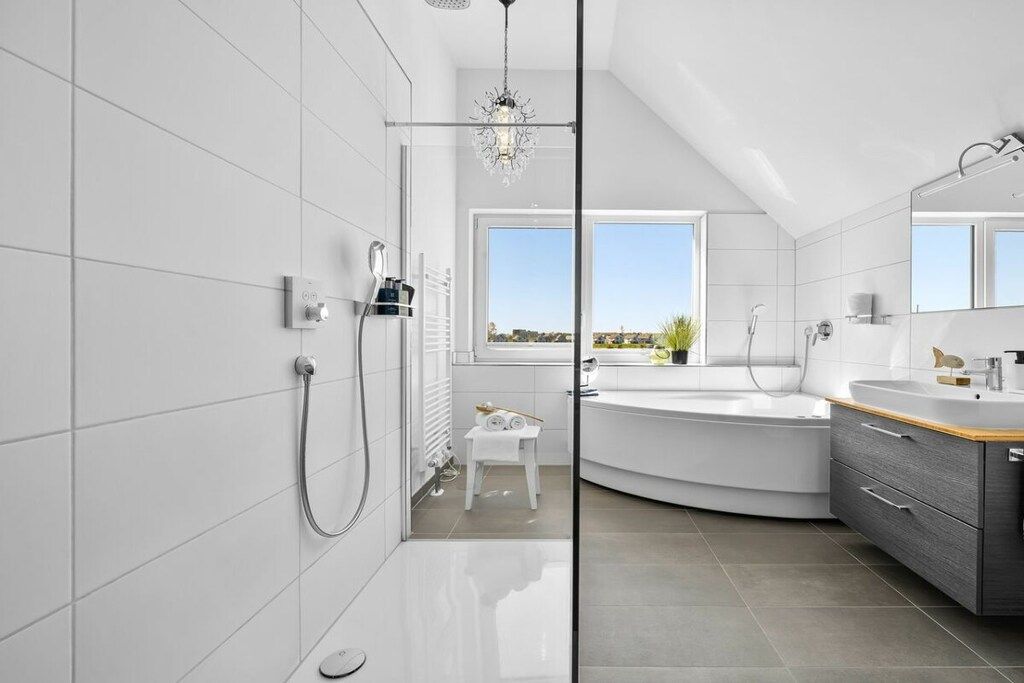 Une salle de bain moderne équipée d’une douche, d’une baignoire et d’un meuble-lavabo avec un miroir.