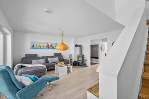 Ein modernes Wohnzimmer mit einer Couch, einem Couchtisch und einer Hängeleuchte.