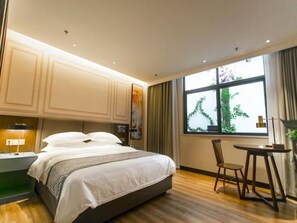 A hotel room with a bed, a desk, a chair, and a large window with curtains. - Gem Bozhou Qiaocheng District Jian 'an Road Railway Station Hotel (Bozhou)