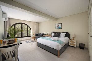 A modern bedroom with a large bed, a dining area, and a view through a window. - Vintage stay bait assel by spacey 105 (cairo)