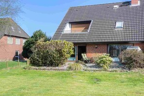 A two-story house with a sloped roof, a visible attic window, and a front door. - Holiday apartment 3 "Little Seagull" (ID 030) (St. Peter-Dorf)
