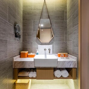 Une salle de bain moderne avec un grand miroir, deux lavabos et un porte-serviettes.