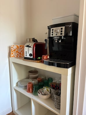 A kitchen counter with a toaster, a coffee maker, and various kitchenware.