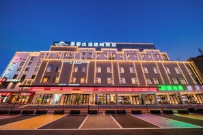 A modern hotel building with multiple floors, large windows, and a prominent signage. - Microtel by Wyndham Huangshan Tangkou (Huangshan)