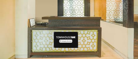 Un comptoir d’accueil avec une pancarte indiquant : « TOWNHOUSE OAK, services d’entreprise. »