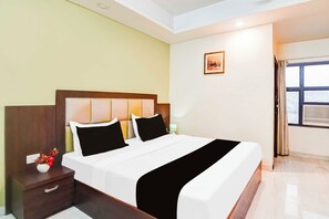 A hotel room with a bed, nightstand, lamp, and a window with curtains. - Townhouse Oak Sikar Road Jaipur (Jaipur)