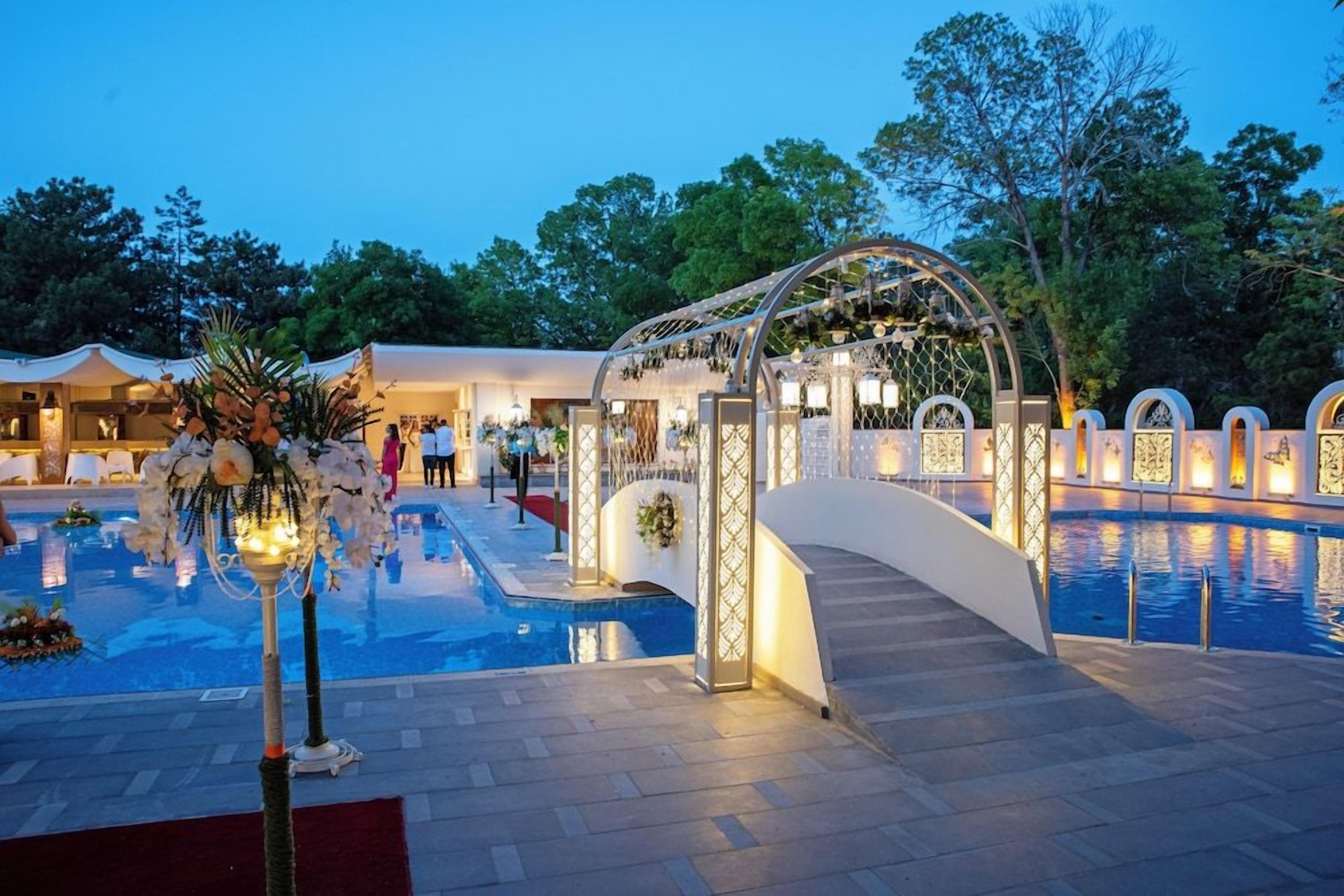 A pool area with a decorative archway and a flower arrangement.