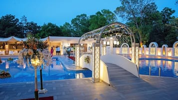 A pool area with a decorative archway and a flower arrangement.