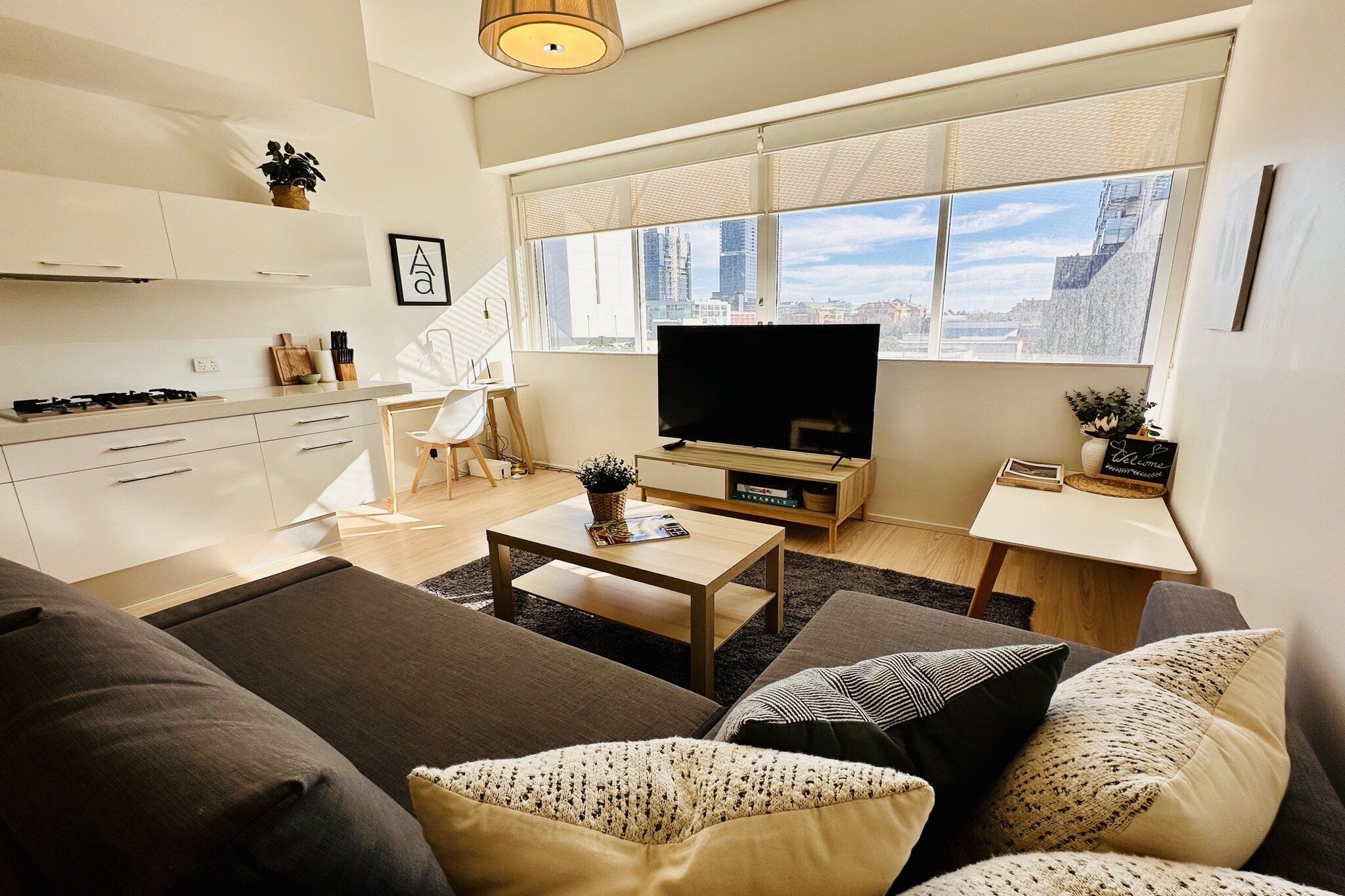 A modern living room with a sofa, coffee table, and a TV.