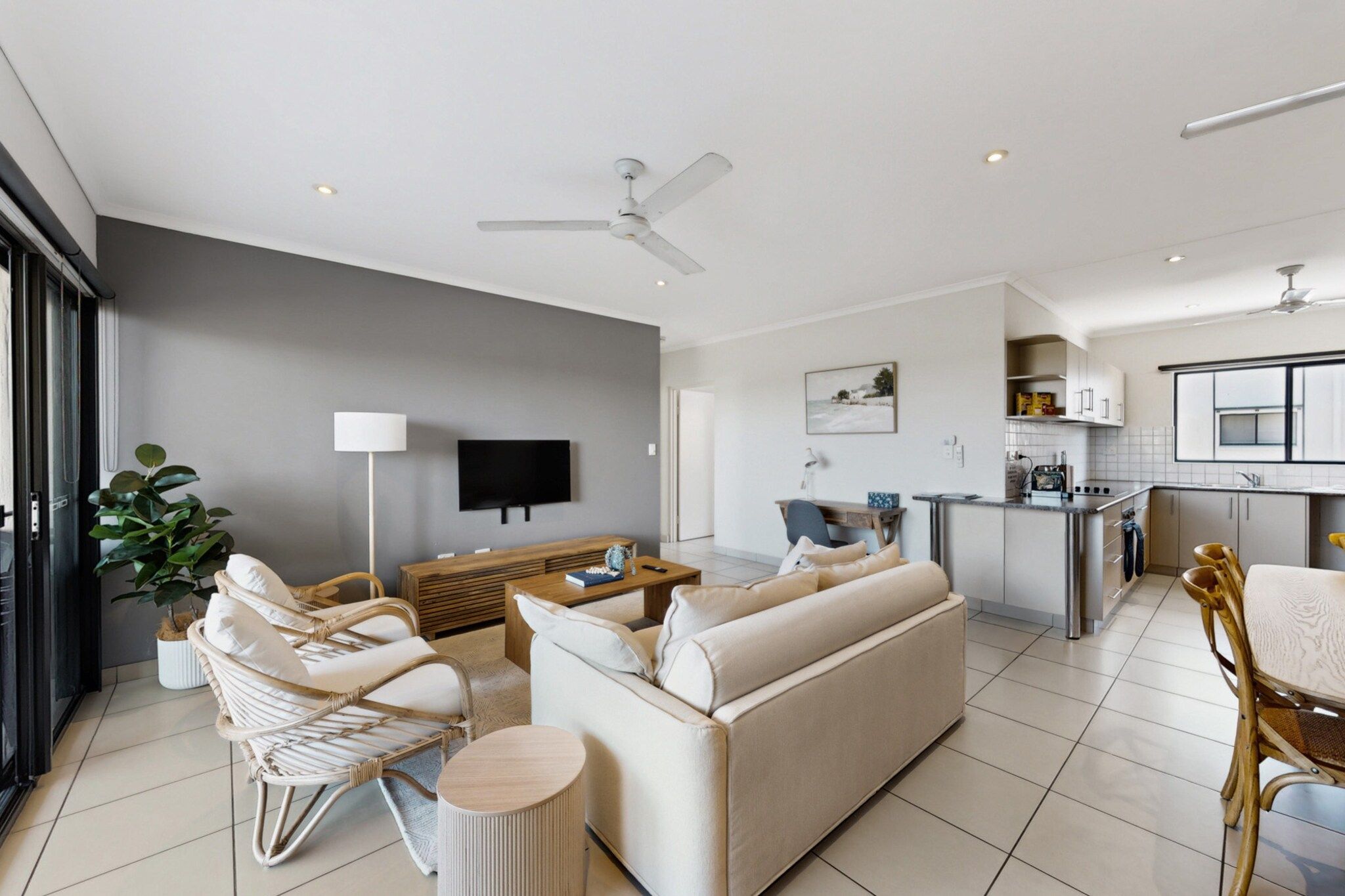 A modern living room with a sofa, chairs, and a TV.