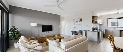 A modern living room with a sofa, chairs, and a TV.
