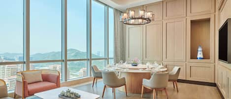 A modern dining area with a round table, chairs, and a chandelier.