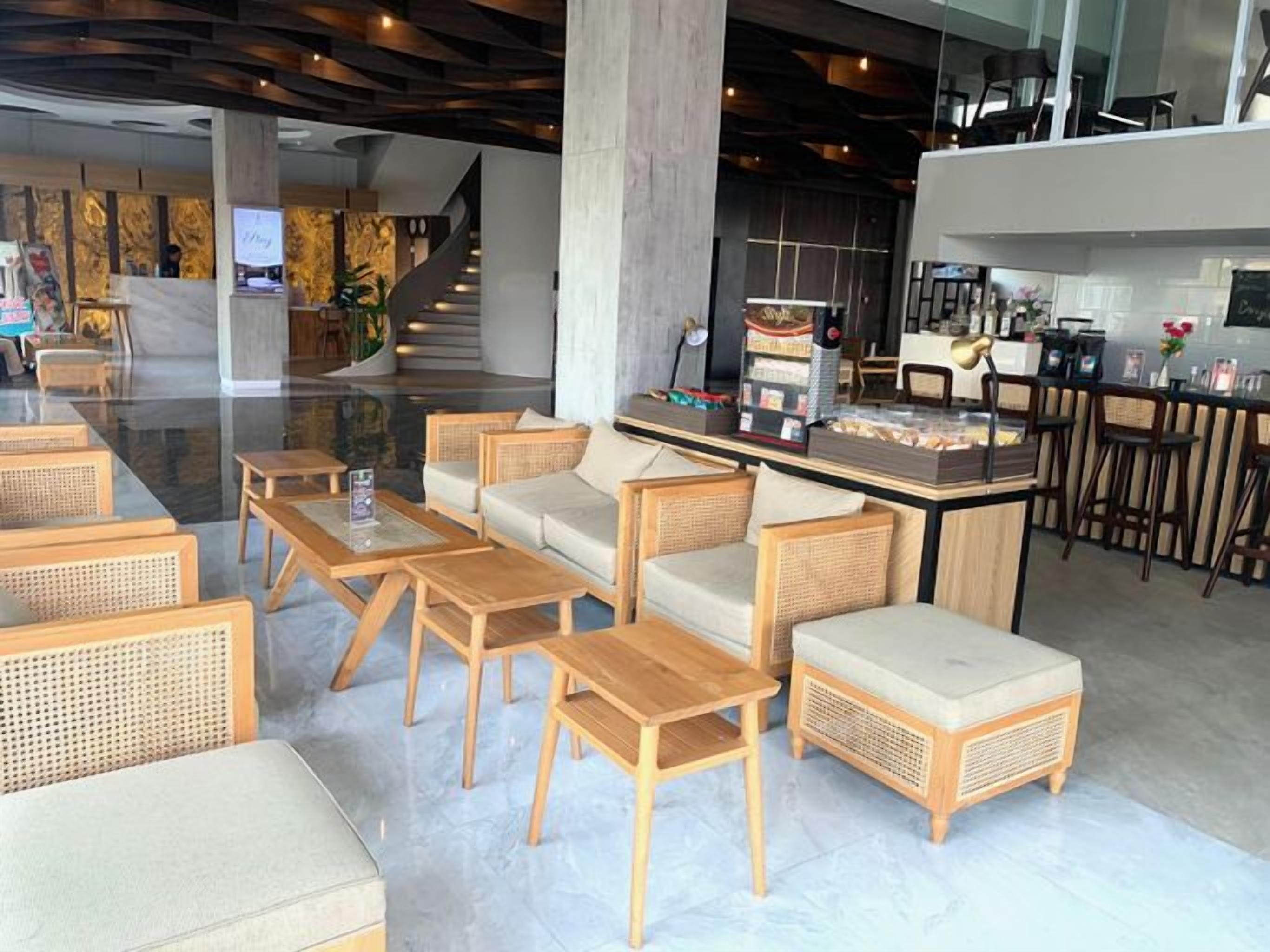 Eine moderne Lobby mit Sitzbereichen, einer Bar und einer Treppe.