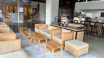 Eine moderne Lobby mit Sitzbereichen, einer Bar und einer Treppe.