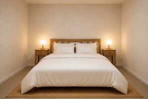 A bed with a wooden headboard, two bedside tables with lamps, and a woven rug. - 1-Bed Apartment Near Darwin Waterfront (Darwin City)