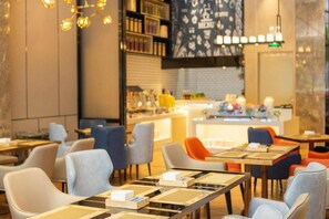 A modern restaurant interior with tables and chairs, a bar area, and a menu display. - Echarm Hotel (Shenzhen)
