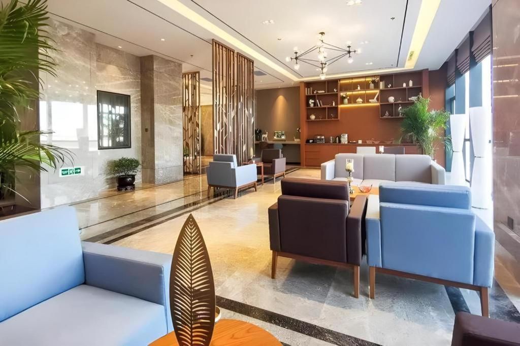 A modern lobby with seating, a reception desk, and a bookshelf.