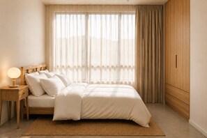 Ein Schlafzimmer mit Bett, Nachttisch, Lampe und Kleiderschrank.