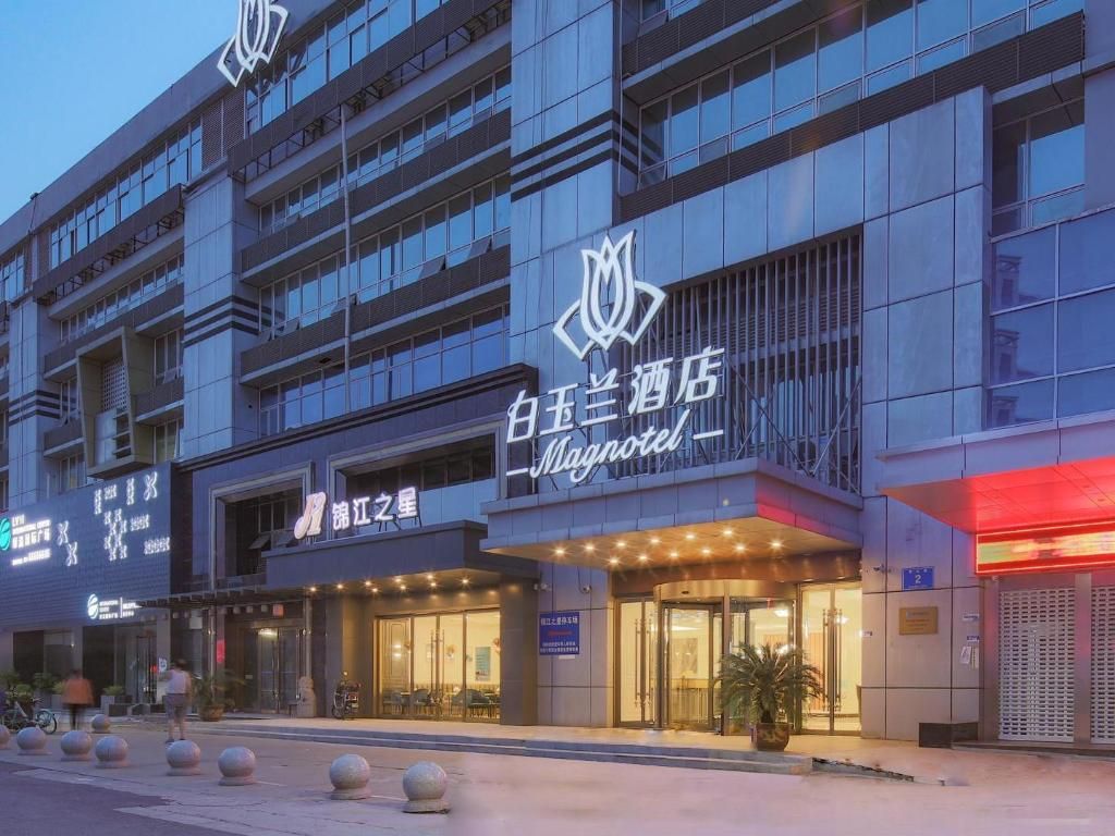 Ein Hotel mit moderner Fassade, mehreren Etagen und einem markanten Logo.