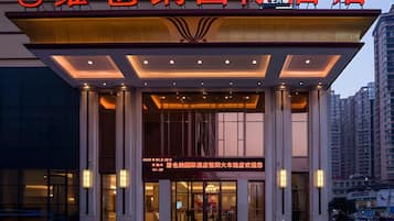 A hotel entrance with a prominent sign, large columns, and a modern design.