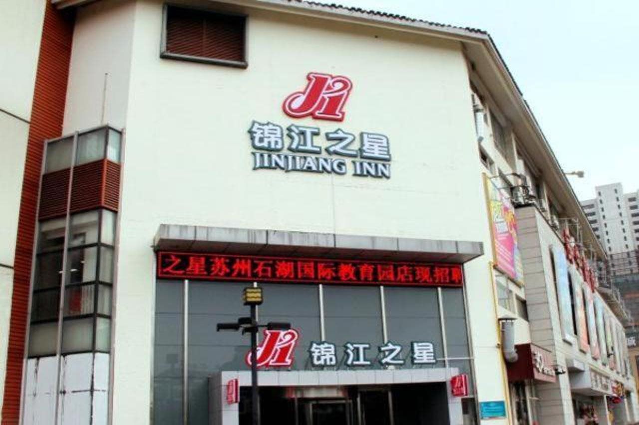 A building with signage for Jintang Inn, featuring a prominent logo and Chinese characters.