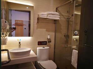A modern bathroom with a large sink, toilet, and glass-enclosed shower. - 7-day Youpin Hotel (Beijing)