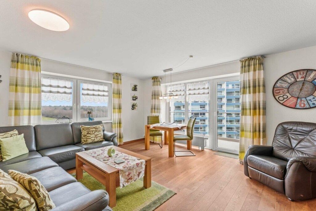 Un salon comprenant un canapé, une table basse et un coin repas avec une table et des chaises.