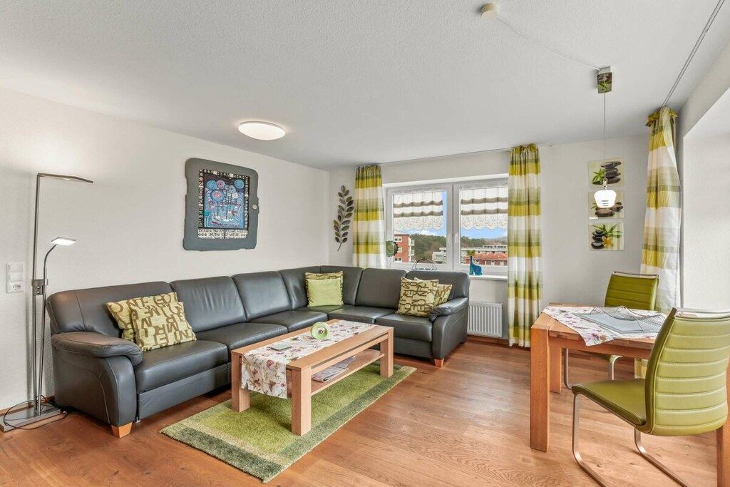 Ein Wohnzimmer mit einer Couch, einem Couchtisch und einem Essbereich mit Tisch und Stühlen.