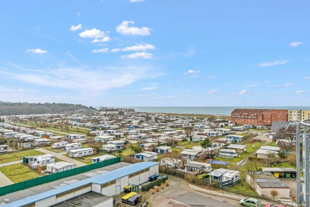 Un parque de caravanas con varias caravanas y un edificio grande al frente.