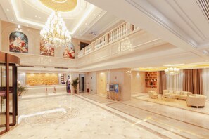 A spacious lobby with a grand chandelier, a reception desk, and a seating area with sofas. - Anyi Jinding Hotel (Nanchang)