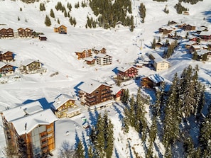 En snedækket landsby med træhuse, skibakker og skilifte.