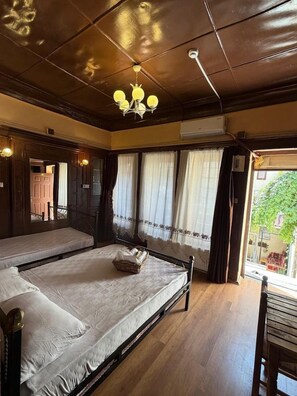 Una habitación con dos camas, un candelabro y vistas al exterior.