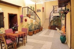 Un ambiente acogedor con zona de comedor, plantas en macetas y una escalera.