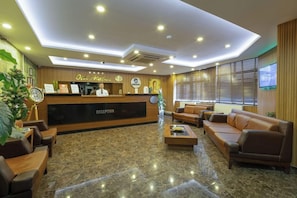 A hotel reception area with a reception desk, seating arrangements, and a large window. - Hotel Atabay (Istanbul)