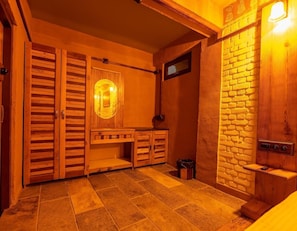 A wooden interior with a bench, a wall-mounted light, and a brick wall. - Blusalzz Homes - The Himalayan Bungalow, Almora - Uttarakhand by Zuzu (Almora)