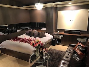 Ett hotellrum med en stor säng, en minibar, en sittgrupp och en TV.