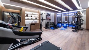 Un gimnasio moderno con cintas de correr, máquinas de pesas y pelotas de ejercicio.
