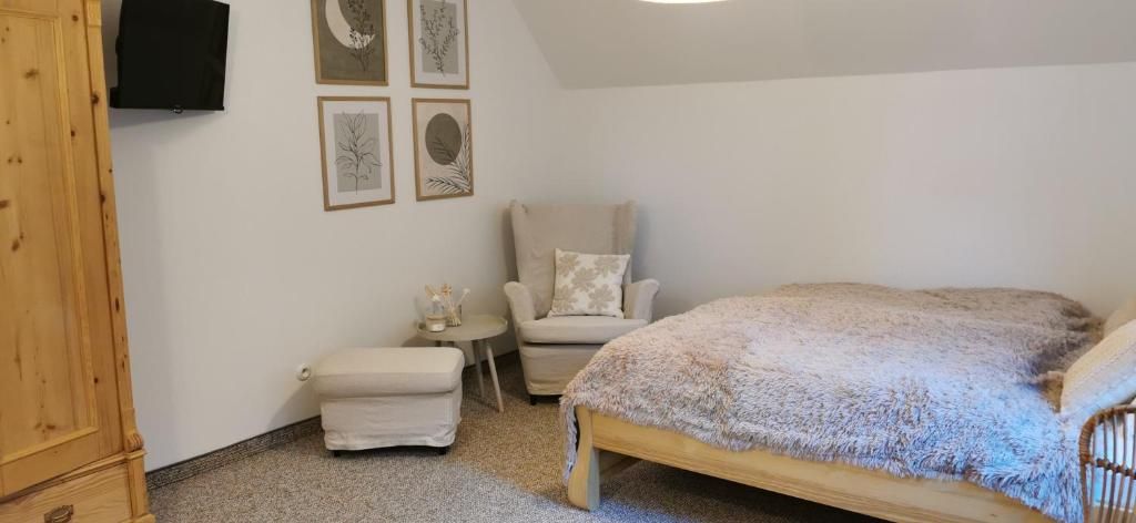 Un dormitorio con cama, una silla, una mesita y un armario.
