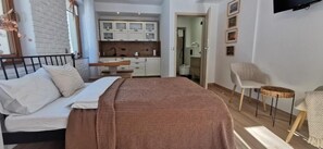 A bedroom with a bed, a bedside table, a chair, and a small round table.