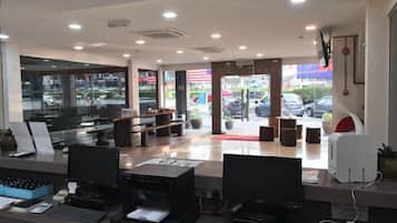 A reception area with a desk, computer, printer, and seating area.