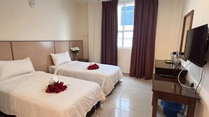 A hotel room with two beds, a TV, and a window with curtains. - Chariton Skudai Hotel (Johor Bahru)