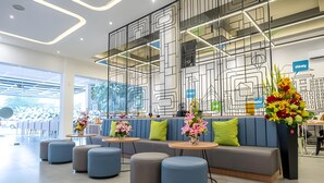 Un interior moderno con zona de estar, mesas redondas y flores decorativas.