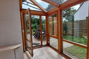 A room with a glass door leading to an outdoor area with chairs and a table. - Holiday apartment with 4 bedrooms (Cuxhaven)