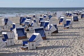 Rows of beach chairs with numbers on them, arranged on a sandy beach. - Sylt Dream Sea View Metropol (Westerland)