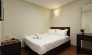 A hotel room with a bed, a bedside table, a nightstand, a mirror, and a wall-mounted light fixture. - Ibilik Hotel @ Johor Bahru (Johor Bahru)