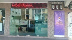 A hotel entrance with a digital sign, a glass door, and a purple banner advertising hotel services. - Ibilik Hotel @ Johor Bahru (Johor Bahru)