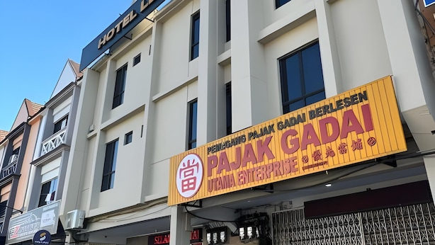 Un hotel con un letrero que dice 'Hotel Ledang Utara' y un letrero de 'Pajak Gadai Berles' debajo.