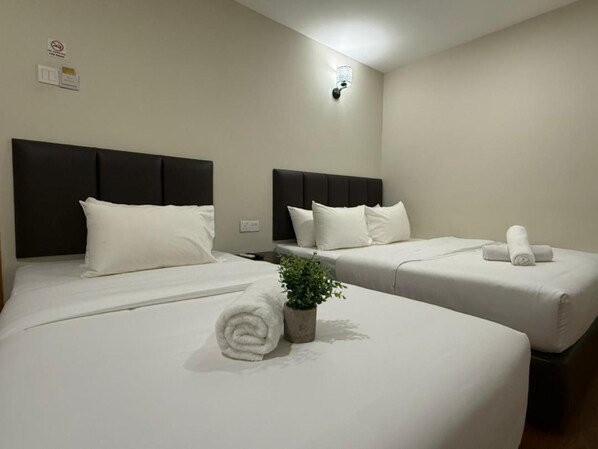 A hotel room with two beds, each with a headboard, white bedding, and a rolled towel on one bed. - Ibilik Hotel @ Johor Bahru (Johor Bahru)