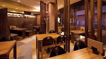 A restaurant with wooden furniture, recessed lighting, and a brick wall.