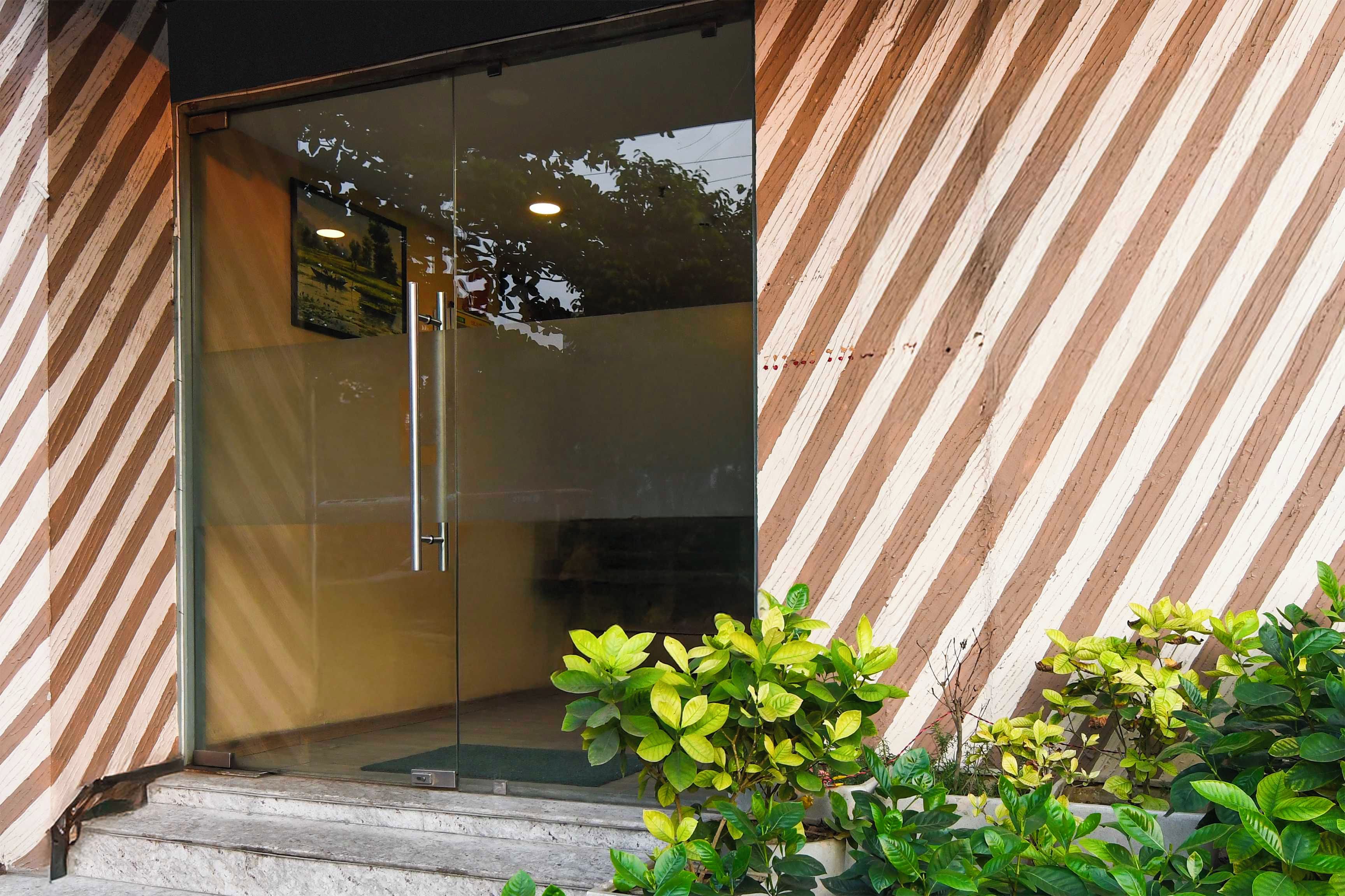 A modern building entrance with a glass door and a striped exterior wall.